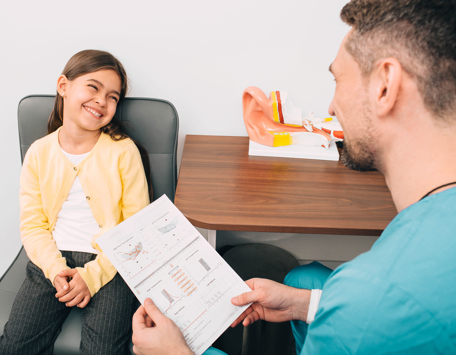 audiologist going over results of hearing test with little girl